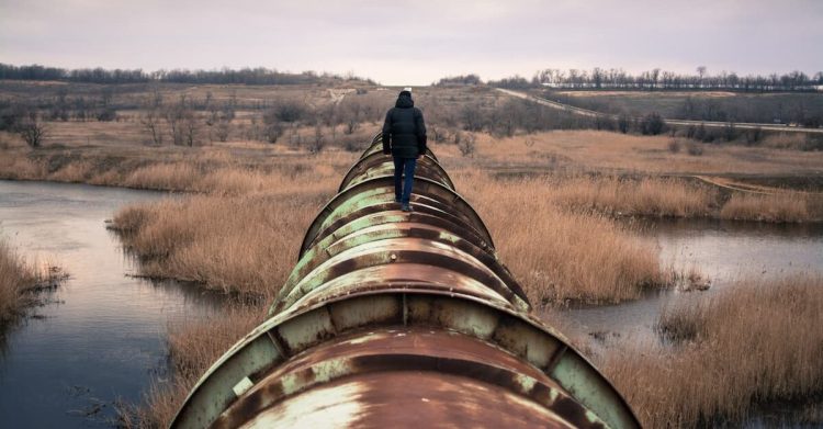 Person walking on pipe. Photo by Rodion Kutsaiev, Unsplash